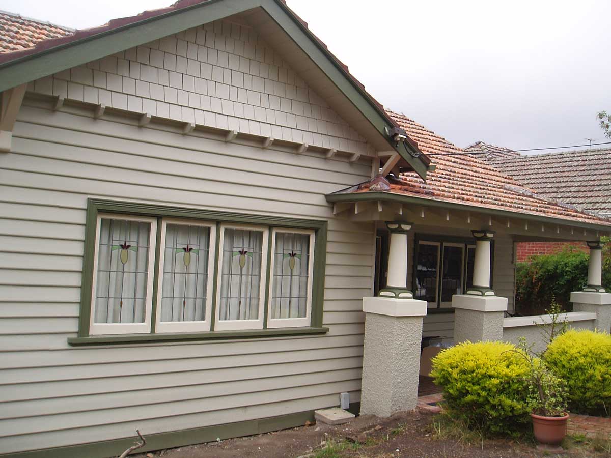 Repainted weatherboard bungalow, green trim, leadlight windows